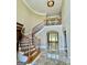 Grand foyer featuring a curved staircase, marble floors, and elegant lighting at 345 Peaceful Way, Fayetteville, GA 30214