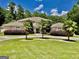Stunning home featuring a circular driveway, lush landscaping, and mature palm trees at 345 Peaceful Way, Fayetteville, GA 30214