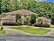 Beautiful home showcasing manicured landscaping, a circular driveway, and classic architectural design at 345 Peaceful Way, Fayetteville, GA 30214