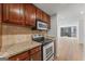 Modern kitchen with stainless steel appliances, granite countertops, and wood cabinets with views to the living area at 1280 W Peachtreestreetsuffix=Street Nw # 808, Atlanta, GA 30309