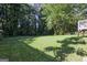 Lush backyard featuring a vast green lawn and mature trees, perfect for outdoor activities and relaxation at 1349 Heather Cir, Riverdale, GA 30296