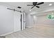 Finished basement showcases a sliding barn door and wood-look floors at 1349 Heather Cir, Riverdale, GA 30296