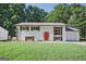 Charming renovated home featuring a vibrant front door, white painted brick, green lawn, and lush, mature trees at 1349 Heather Cir, Riverdale, GA 30296