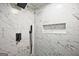 Close-up of marble-look shower with black fixtures and built-in niche at 1349 Heather Cir, Riverdale, GA 30296