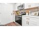 Modern kitchen featuring stainless steel appliances, white cabinets, and stylish subway tile backsplash at 1675 White Oak Way, Decatur, GA 30032