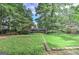 Expansive backyard with lush green grass and mature trees, complemented by stone landscaping and a private fence at 4920 Tremont Ne Dr, Marietta, GA 30066
