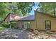 Tan two-story home exterior featuring a stone patio, green plants, and a mature tree canopy at 4920 Tremont Ne Dr, Marietta, GA 30066