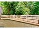 Large concrete patio with a wood fence surrounding a private yard that is shaded by mature trees at 2821 Amhurst Nw Way, Kennesaw, GA 30144