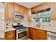 Spacious kitchen featuring wood cabinets, stainless steel appliances, granite countertops, and tile backsplash at 2821 Amhurst Nw Way, Kennesaw, GA 30144