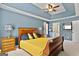 Comfortable bedroom featuring a tray ceiling, ceiling fan, and en suite bathroom at 2821 Amhurst Nw Way, Kennesaw, GA 30144
