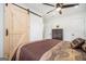 Bedroom featuring a sliding barn door, ceiling fan, and closet with drawers at 4020 Ester Sw Dr, Atlanta, GA 30331