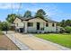 Lovely home showcasing a gated driveway and inviting exterior, surrounded by green lawn and mature trees at 4020 Ester Sw Dr, Atlanta, GA 30331