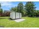 Backyard featuring white storage shed with double doors and a concrete and gravel pad in a green grassy yard at 4020 Ester Sw Dr, Atlanta, GA 30331