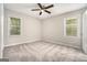 A serene bedroom with neutral walls, plush gray carpet, and natural light streaming through two windows at 114 Howell Dr, Atlanta, GA 30331