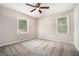 Serene bedroom featuring plush gray carpet, two bright windows, and a cozy ceiling fan at 114 Howell Dr, Atlanta, GA 30331