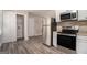 Modern kitchen with stainless steel appliances, white cabinets, and practical layout with laundry access at 114 Howell Dr, Atlanta, GA 30331