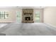 Bright living room featuring a stone fireplace, plush carpeting, and natural light from multiple windows at 9719 Dixon Industrial, Jonesboro, GA 30236