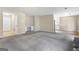 Open living room with gray carpet, built-in shelves, and seamless access to the kitchen at 9719 Dixon Industrial, Jonesboro, GA 30236