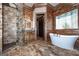 Luxurious bathroom featuring a soaking tub, walk-in shower, and wood-look tile at 297 Collegiate Dr, Powder Springs, GA 30127