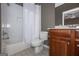 Bathroom featuring a white tiled shower/tub, toilet, vanity with a sink and mirror at 297 Collegiate Dr, Powder Springs, GA 30127