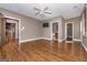Spacious bedroom features wood floors, ceiling fan, TV, and doorways to closets and bathroom at 297 Collegiate Dr, Powder Springs, GA 30127