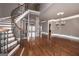 Elegant foyer featuring a curved staircase, hardwood floors, and stone pillar accent at 297 Collegiate Dr, Powder Springs, GA 30127