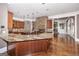 Open kitchen boasts granite counters, hardwood floors, stainless appliances, and a stone fireplace accent at 297 Collegiate Dr, Powder Springs, GA 30127