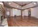 Open living room with fireplace, hardwood floors, tray ceiling, and access to other rooms at 297 Collegiate Dr, Powder Springs, GA 30127