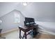This attic office space has neutral colored walls, a window, and a desk with computer at 3015 Arbor Song Ct, Cumming, GA 30041