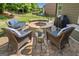 Cozy backyard stone fire pit area with comfortable wicker chairs and a grill for outdoor entertaining at 3015 Arbor Song Ct, Cumming, GA 30041
