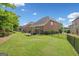 Expansive backyard features lush green lawn, iron fencing and a covered patio area perfect for outdoor living at 3015 Arbor Song Ct, Cumming, GA 30041