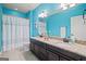 This bathroom has double sinks, granite countertops and bright blue walls at 3015 Arbor Song Ct, Cumming, GA 30041