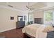 Cozy bedroom features hardwood floors, a ceiling fan, and two large windows at 3015 Arbor Song Ct, Cumming, GA 30041