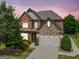 Charming two-story home featuring a brick and stone facade, well-manicured lawn, and a two-car garage at 3015 Arbor Song Ct, Cumming, GA 30041