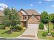Charming two-story home featuring a brick and stone facade, well-manicured lawn, and a two-car garage at 3015 Arbor Song Ct, Cumming, GA 30041