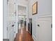 Hallway featuring hardwood floors, access to multiple rooms, and a built-in beverage cooler at 3015 Arbor Song Ct, Cumming, GA 30041