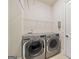 Functional laundry room with front loading washer and dryer, plus built in shelving at 3015 Arbor Song Ct, Cumming, GA 30041