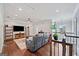 This large living room features hardwood floors, a ceiling fan, and a large window for natural light at 3015 Arbor Song Ct, Cumming, GA 30041