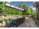 An outdoor seating area with pergola is surrounded by lush greenery and manicured landscaping at 3015 Arbor Song Ct, Cumming, GA 30041
