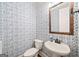 Stylish powder room featuring patterned wallpaper, a pedestal sink and a framed mirror at 3015 Arbor Song Ct, Cumming, GA 30041