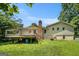 Backyard view featuring a deck, brick chimney, and lush greenery on a sunny day at 2067 Skyhawk Ln, Acworth, GA 30102