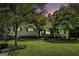 Charming ranch home featuring a well-manicured lawn and lush trees at dusk at 2067 Skyhawk Ln, Acworth, GA 30102