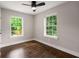 Bright, empty bedroom with beautiful hardwood floors, ceiling fan and two large windows at 345 Adelle Se St, Atlanta, GA 30315