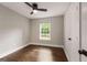 Bright bedroom with hardwood floors, white trim, a ceiling fan, and a window overlooking the greenery at 345 Adelle Se St, Atlanta, GA 30315