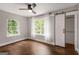 Bedroom featuring hardwood floors, a ceiling fan, two windows, and a barn door at 345 Adelle Se St, Atlanta, GA 30315