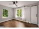 Bedroom featuring hardwood floors, a ceiling fan, two windows, and a barn door at 345 Adelle Se St, Atlanta, GA 30315