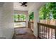 View of covered porch with brick arches, white brick columns, and view of the front yard with mature trees at 345 Adelle Se St, Atlanta, GA 30315