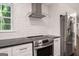 Updated kitchen featuring a stainless steel range hood, range, black countertops and stainless steel refrigerator at 345 Adelle Se St, Atlanta, GA 30315