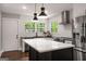 Modern kitchen with white subway tile, stainless steel appliances, black countertops, and a large island at 345 Adelle Se St, Atlanta, GA 30315
