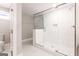 Bright bathroom featuring a glass enclosed shower, a toilet, white tiled walls and floors with natural light at 870 Gaston Sw St, Atlanta, GA 30310